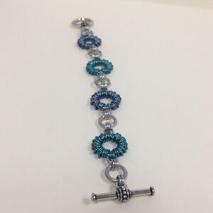 Hand woven blue and aqua ring bracelet.